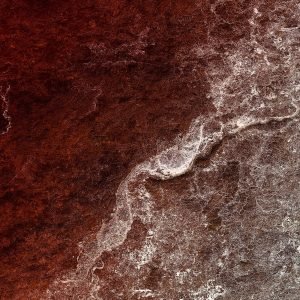 Close-up photograph of a basalt stone with white residue, creatively recolored in dark red to depict a sea of blood and rolling waves.