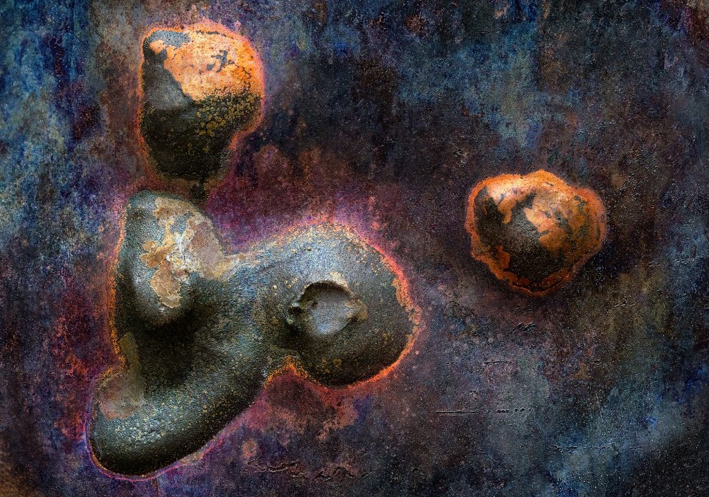 "Mother": Close-up photograph of welded metal pieces in dark blue, purple, black, and brownish tones, resembling humanoid and spherical forms amidst an intense orange corona, evoking themes of creation and evolution.