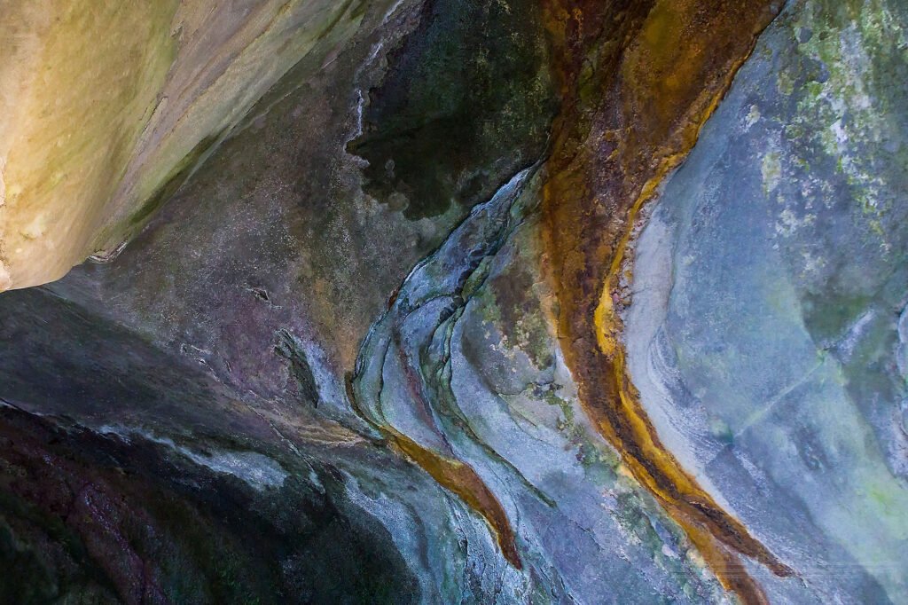 An organically shaped stone formation in earthy tones, appearing both in motion and frozen — as if lingering in slow transformation for eons.