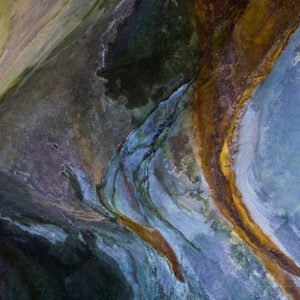 An organically shaped stone formation in earthy tones, appearing both in motion and frozen — as if lingering in slow transformation for eons.